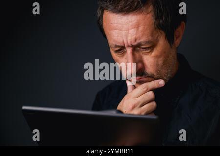 Man using digital tablet computer, low key with selective focus Stock Photo