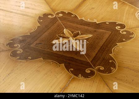 Texture of a flower-shaped inlay, on a wooden table top Stock Photo