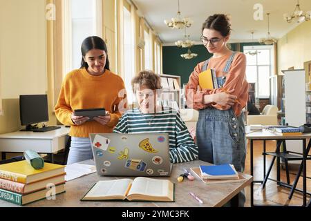 Collaborating in Study Room with Electronic Devices Stock Photo