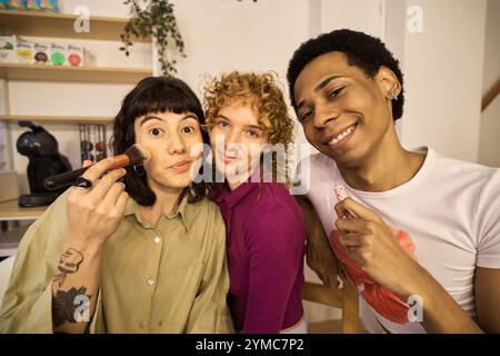 Multiethnic friends applying makeup together at home Stock Photo