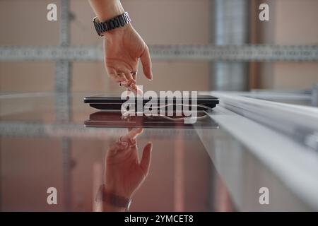 Low angle view of female hand unlocking office door using touch screen on wall, modern security system concept, copy space Stock Photo