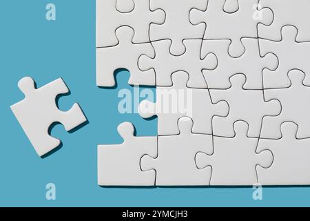 Jigsaw puzzle with missing piece on blue background Stock Photo