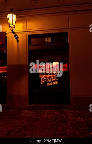 Window shop with quote by Franz Kafka lit up in neon in Male namesti, by night, in Old Town, Prague, Czech Republic. Stock Photo