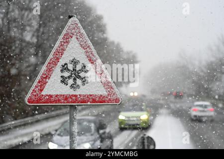 Leer, Germany. 21st Nov, 2024. A traffic sign on the Südring bridge warns of the danger of slippery snow or ice on the road while snow is falling. Credit: Lars Penning/dpa/Alamy Live News Stock Photo