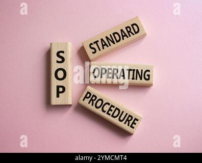 SOP - Standard Operating Procedure symbol. Wooden blocks with word SOP. Beautiful pink background. Business and SOP concept. Copy space. Stock Photo