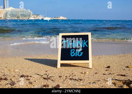 Think big symbol. Concept words Think Big on black chalk background. Beautiful sea background. Business and Think big concept. Copy space. Stock Photo
