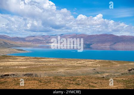 The sacred Manasarovar lake with blue transparent water in the mountains of Tibet under cloudy sky. Ngari scenery in West Tibet. Sacred place for Budd Stock Photo