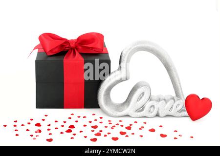 Valentines day gift box, love sign and scattered hearts on white background. Romantic loving concept for a Valentine card, anniversary or birthday. Stock Photo