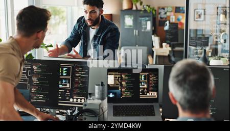 Men, discussion and programmer with computer for coding solutions, problem solving or idea at office. Male people, designers or developers working on Stock Photo
