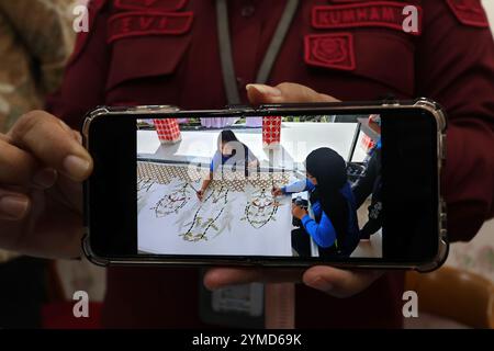 November 21, 2024, Gunung Kidul, Yogyakarta Special Region, INDONESIA: Head of the Class IIB Women's Penitentiary, Evi Loliancy, shows the latest photo of Filipino death row inmate Mary Jane Veloso (left) making batik, at a press conference in Wonosari, Yogyakarta, Thursday, November 21 2024. Mary Jane Veloso is a woman from the Philippines who sentenced to death in Indonesia on drug smuggling charges. Philippine President Ferdinand Marcos Jr. said on Wednesday that an agreement had been reached for Indonesia to repatriate a Filipino death row drug convict who was nearly executed by firing squ Stock Photo