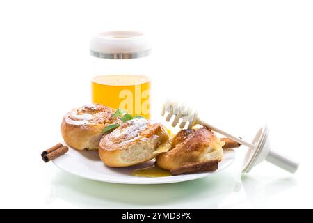 Baked goods. Sweet buns with cottage cheese filling and honey in a plate isolated on a white background . Stock Photo