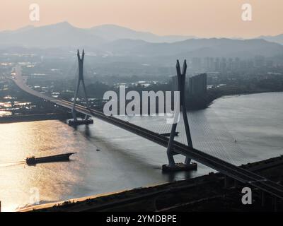 Foshan. 21st Nov, 2024. An aerial drone photo taken on Nov. 21 2024 shows a view of the Fulong Xijiang super major bridge in Foshan, south China's Guangdong Province. Lying in Foshan City, the 1770.6-meter-long bridge connects Gaoming District in the west and Sanshui District in the east. The bridge, scheduled to open to traffic on Friday, will further improve the transportation system of the western area of Guangzhou and Foshan in south China's Guangdong. Credit: Liu Dawei/Xinhua/Alamy Live News Stock Photo