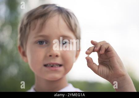 6 years old boy shows the ruptured milk tooth Stock Photo