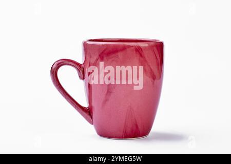 Ceramic mug on white backdrop. Pink cup isolated Stock Photo