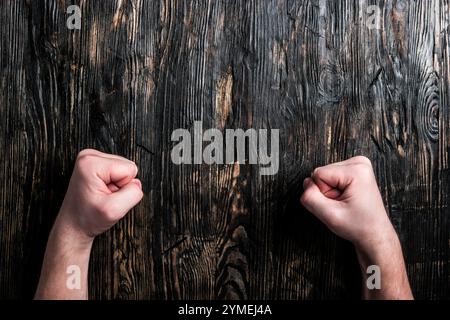 two human fists on empty dark wooden table Stock Photo