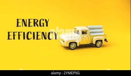 Toy truck with a yellow background and the words energy efficiency written on it. The truck is positioned in the middle of the image and is surrounded Stock Photo