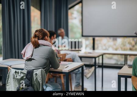 Engaged students in classroom with elderly professor teaching Stock Photo