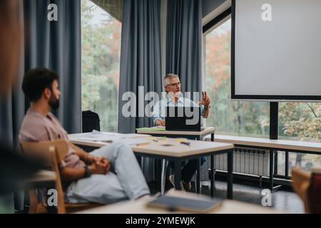 Students engaging with elderly professor in modern classroom setting Stock Photo