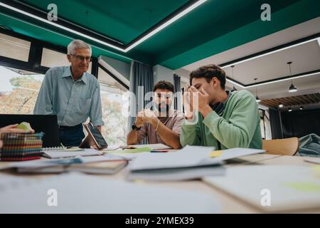 University students collaborating on a project with senior professor guidance Stock Photo