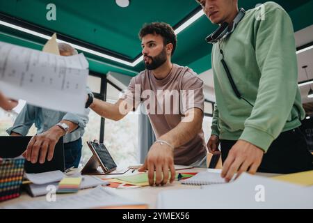 College students collaborating on project with professor in modern classroom Stock Photo