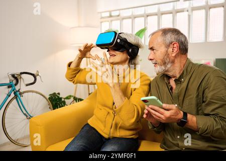 Senior couple exploring virtual reality at home Stock Photo