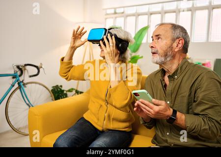 Senior couple exploring virtual reality at home Stock Photo