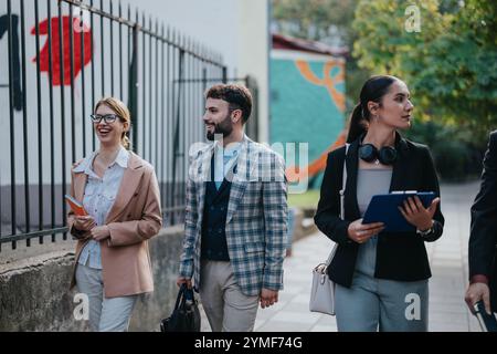 Diverse group of business people walking and talking outdoors Stock Photo