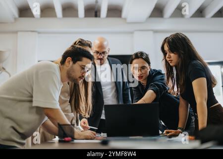 Students collaborating on a project with guidance from their professor Stock Photo