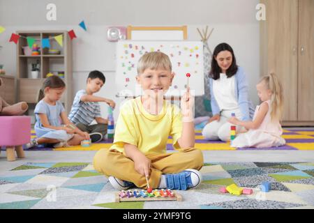 Little boy playing xylophone in kindergarten Stock Photo