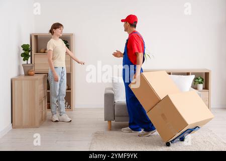 Young woman receiving parcels from delivery man at home Stock Photo