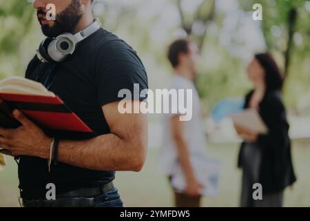 Multicultural students collaborating on assignments in park setting Stock Photo