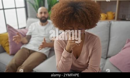 Interracial couple having a serious discussion on a cozy sofa indoors Stock Photo