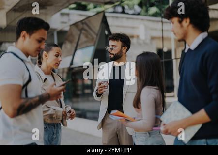 University students engaging with professor in outdoor campus setting Stock Photo