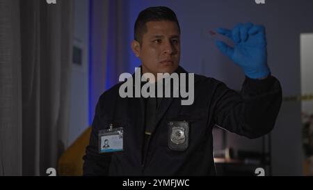 Hispanic detective man examines evidence at indoor crime scene in living room wearing gloves. Stock Photo