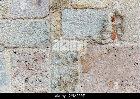 Fragment of an old wall, made of rough stone blocks of different sizes. To be used as abstract backgrounds and textures. Stock Photo