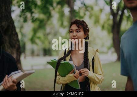 Multicultural students collaborating on school tasks in a park setting Stock Photo