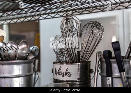 A collection of whisks in a labelled metal container at Helmi Smeulders’ cookery workshop, Djonora Marthaweg, Willemstad, Curaçao, Kòrsou Stock Photo