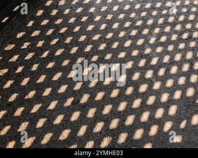 A black and white photo of a road with a pattern of small squares, highlighting the concept of shadows. Perfect for adding a dramatic and artistic tou Stock Photo
