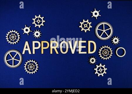 Approved alphabet letters with gears element on navy blue background Stock Photo