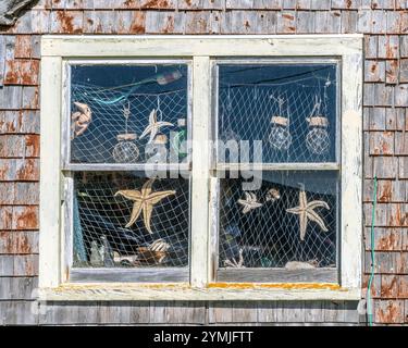 Shop window filled with nautical themed items and curiousities for sale to tourists in Peggy's Cove Nova Scotia. Stock Photo