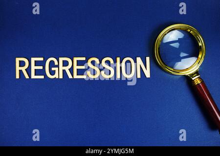 Regression alphabet letters with magnifying glass on navy blue background Stock Photo