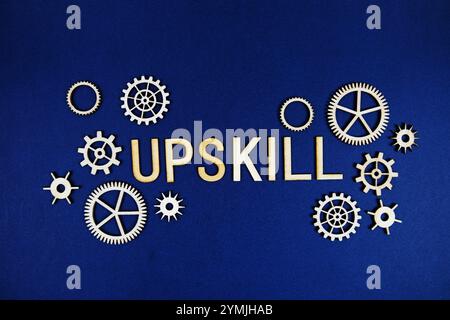 Upskill alphabet letters with gears element on navy blue background Stock Photo