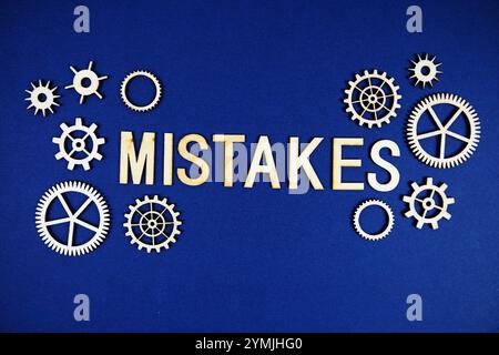 Mistake alphabet letters with gears element on navy blue background Stock Photo