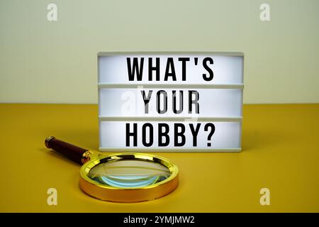 What's Your Hobby? text on LED lightbox with magnifying glass on yellow background Stock Photo