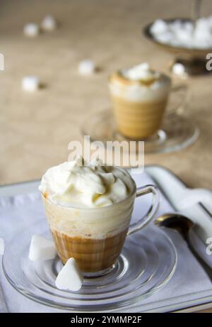 delicious coffee cups with cream on a yellow table cloth,  selective focus Stock Photo