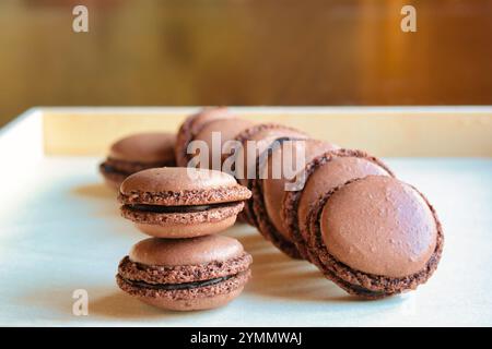 group of homemade chocolate macarons on a wooden tray Stock Photo