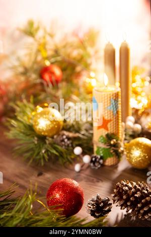 Christmas banner with tree decorations, pine cones and burning candles on wooden background. Merry Christmas Stock Photo