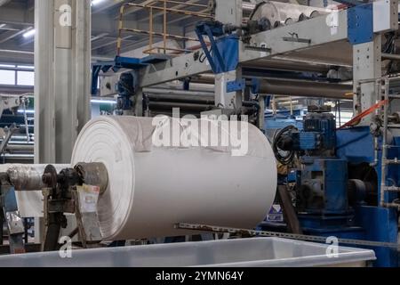 A roll of white fabric in a textile factory in close up view. Stock Photo