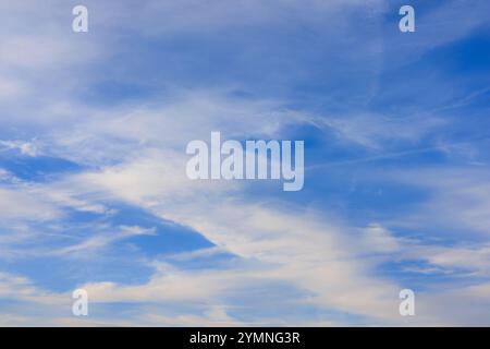 Intersecting lines of beautiful cirrus clouds in a bright blue sky. Afternoon sky. Stock Photo