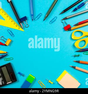 Various colorful markers and stationery items are scattered on a blue surface, showcasing vibrant tools for creativity and organization. Stock Photo